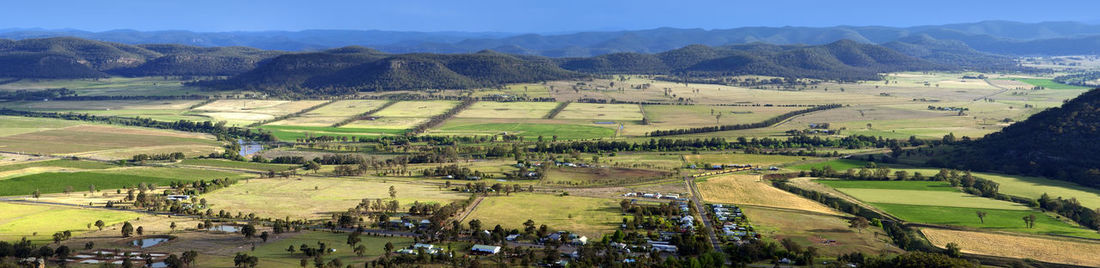 Panoramic view of agricultural field against sky