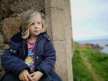 Cute girl sitting against wall