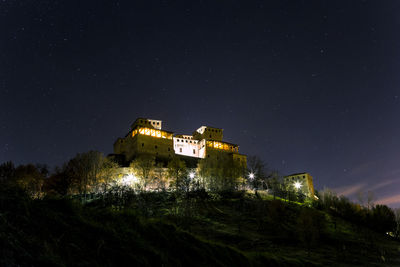 Scenic view of torrechiara castle at night against stars, parma italy