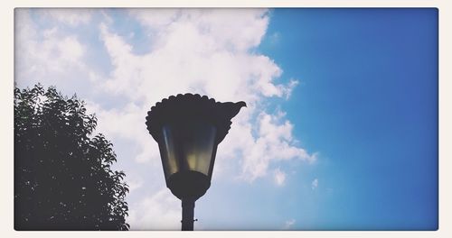 Low angle view of street light against cloudy sky