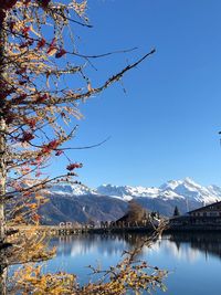 Scenic view of lake by snowcapped mountains against clear sky