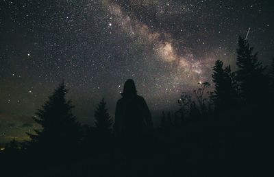 Silhouette woman standing against sky at night