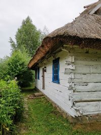 House amidst trees and building against sky