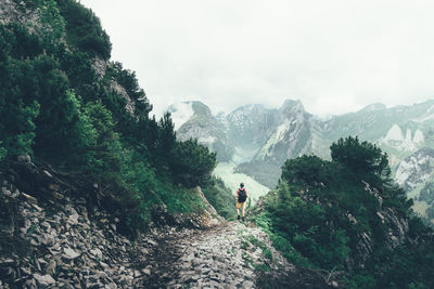 Rear view of hiker standing on rock against alpstein