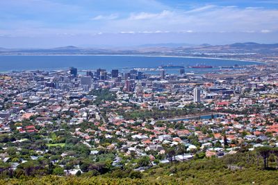 High angle view of townscape by sea against sky