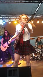 Full length of young woman playing guitar