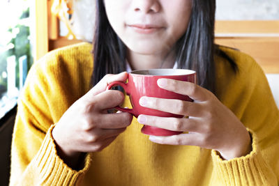 Midsection of woman drinking coffee