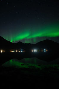 Low angle view of illuminated night sky with northern lights and reflectioni in the water