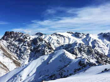 Scenic view of snowcapped mountains against blue sky