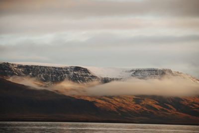 Scenic view of sea and mountains against sky