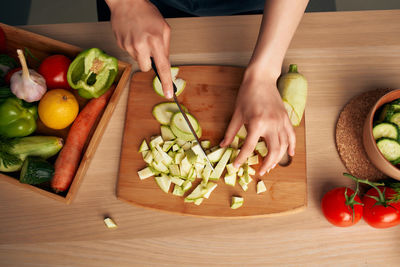Midsection of man preparing fruits on cutting board
