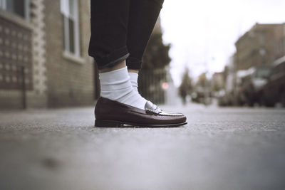 Low section of woman standing on street