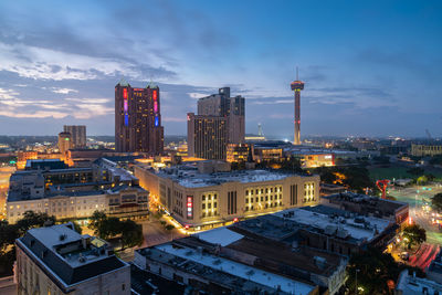 High angle view of city buildings against cloudy sky