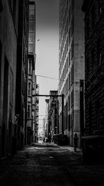 Narrow alley amidst buildings in city against sky