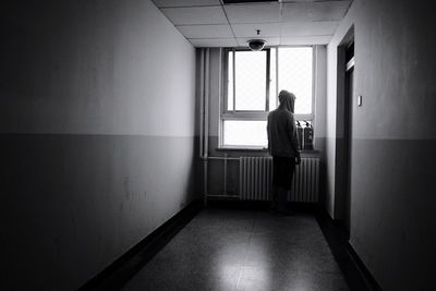 Rear view of woman standing in corridor