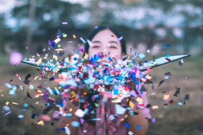 Close-up of woman blowing confetti