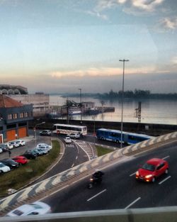 Traffic on road against sky during sunset