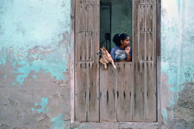 Girl with dog on door of house