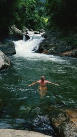 Man swimming in river at forest