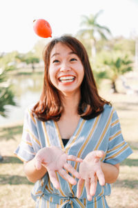 Smiling woman throwing food outdoors