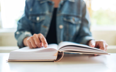 Midsection of woman reading book