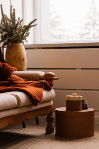 Cozy christmas decor in the living room. fir branches in a vase near a sofa with a blanket 