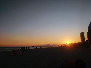 Scenic view of beach against clear sky during sunset