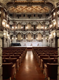 Empty chairs and tables in illuminated building