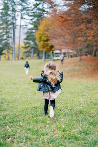 Rear view of woman standing on grassy field