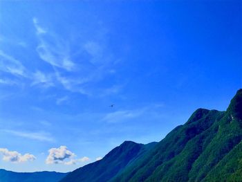 Scenic view of mountains against blue sky