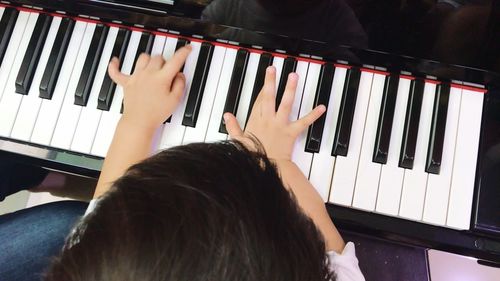 Midsection of child playing piano