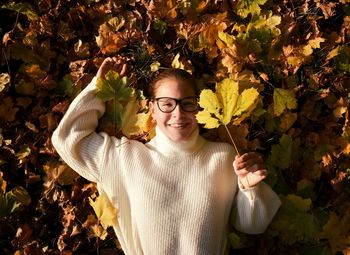 Portrait of smiling young woman with autumn leaves