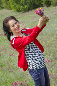 Rear view of a smiling woman walking on grassland