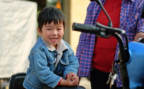 Boy sitting in traditional clothing outdoors