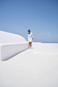 Young woman standing against clear sky