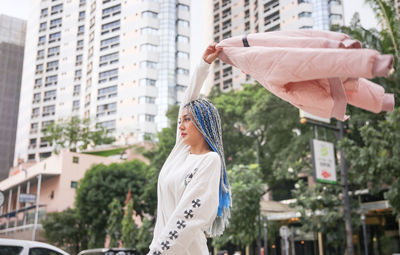 Woman standing against buildings in city