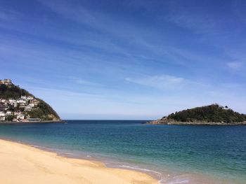 Scenic view of beach against blue sky