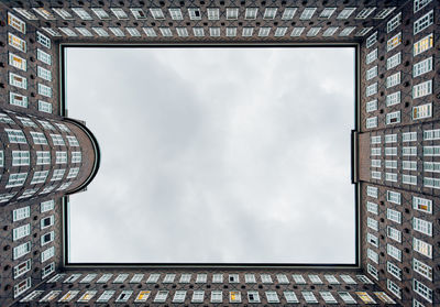 From below famous chilehaus office building with many windows on background of overcast sky located in hamburg