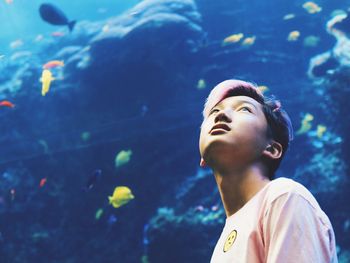 Young man looking away in aquarium