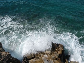 High angle view of waves breaking on rocks