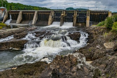 Scenic view of dam and river against sky