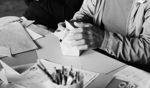 Close-up of hands making cube from paper