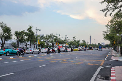 Cars on street against sky