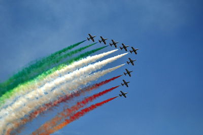 Low angle view of airshow in blue sky