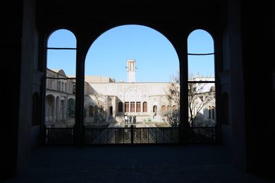 Buildings against blue sky seen through window