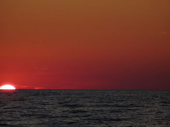 Scenic view of sea against orange sky