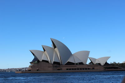 View of buildings in city against clear blue sky