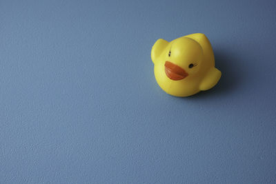 Close-up of yellow toy over blue background