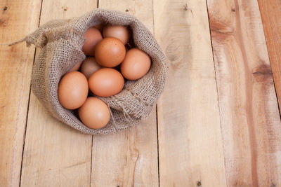 Directly above shot of eggs in container on wood