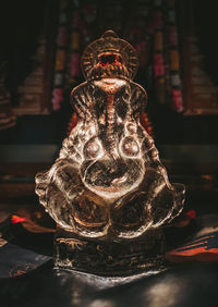 Close-up of buddha statue on table